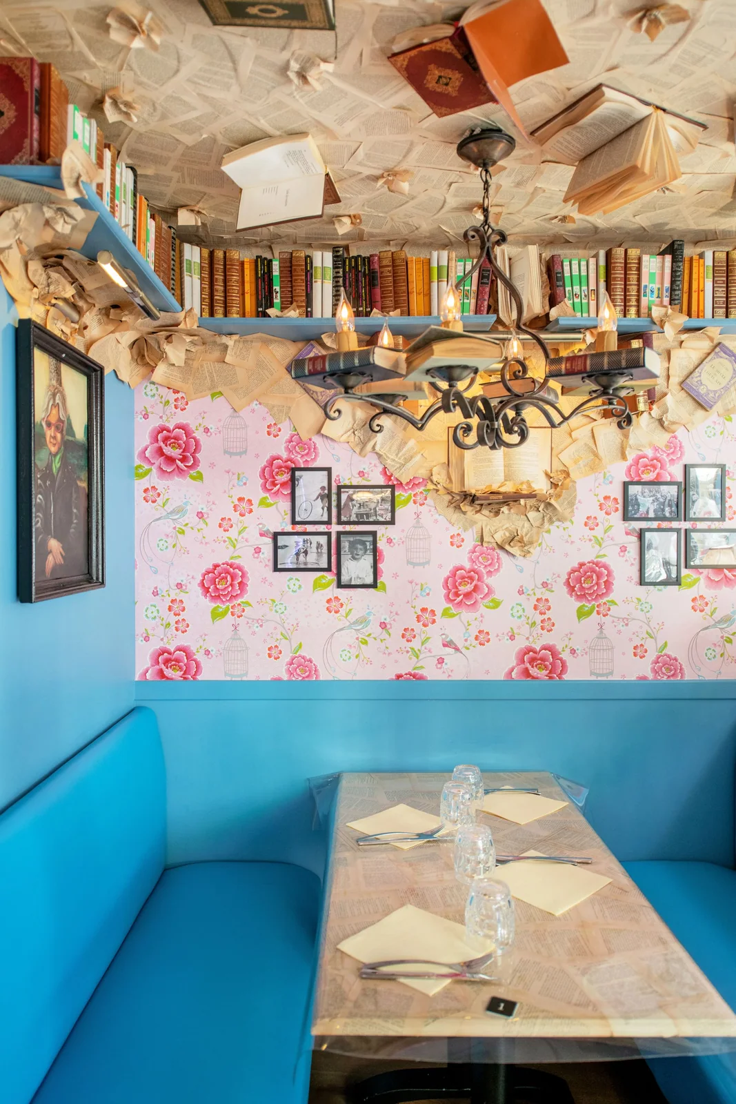 La banquette bleue sous les photos et les fleurs du comptoir de Châteauroux