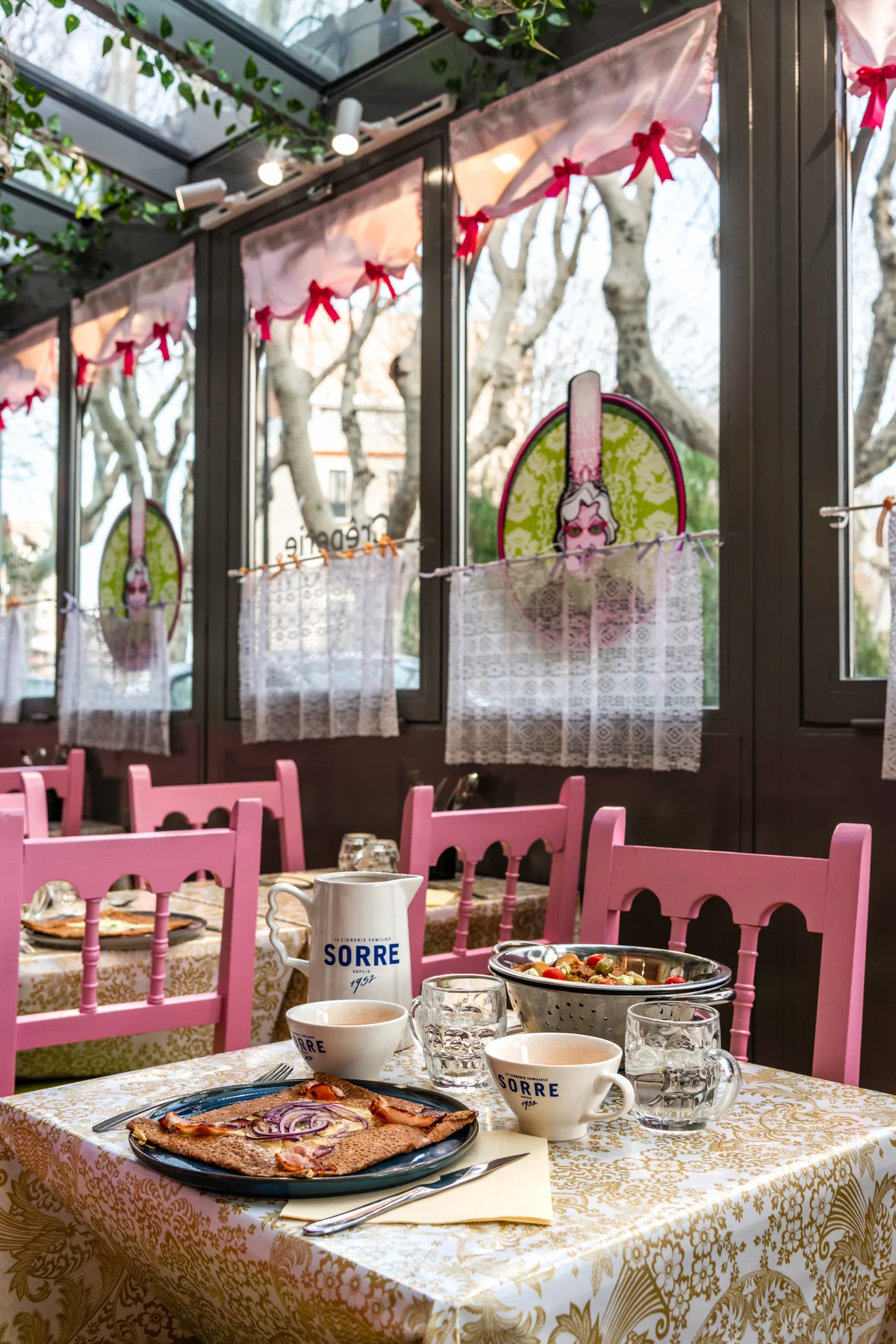 Chaises roses et tables près des vitrages du comptoir de Perpignan